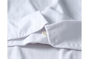 Detalle de una camisa blanca perfectamente planchada en el cuello y los puños.